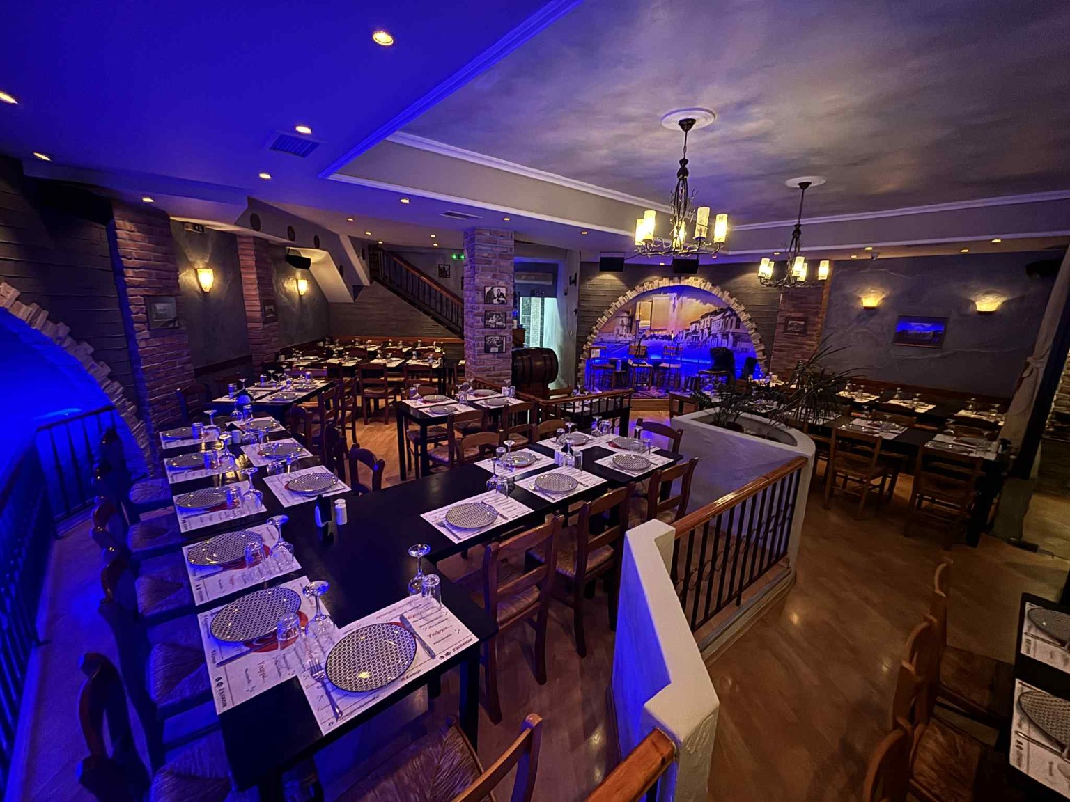 Wide view of the Karnagio dining room with wooden chairs and chandeliers